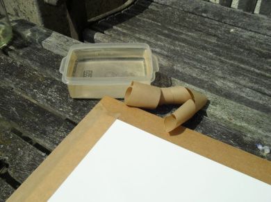 Taping down the soaked paper with brown gummed tape